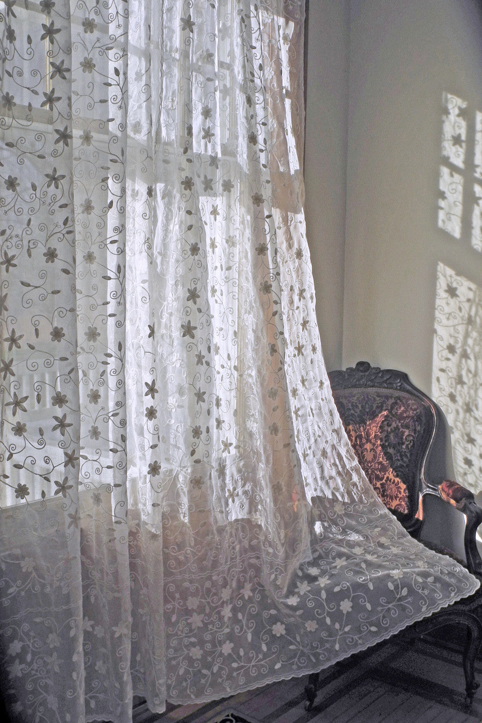 window curtain in cotton organdy embroidered with star like pattern.