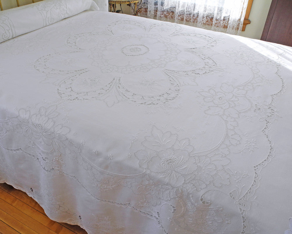 Pure linen bedcover featuring ornate central motif created with cutwork embroidery. Graceful garland like pattern frames the center and all edges, providing for high quality finish. Made by hand on fine quality of 100% linen.