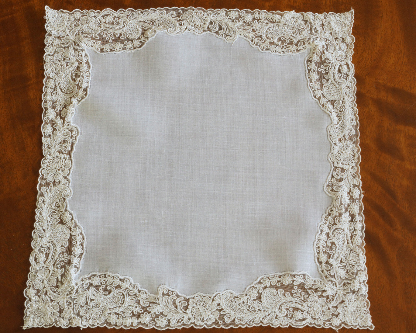 Lovely hankerchief in sheer white linen edged with exquisite lace in off white colour.