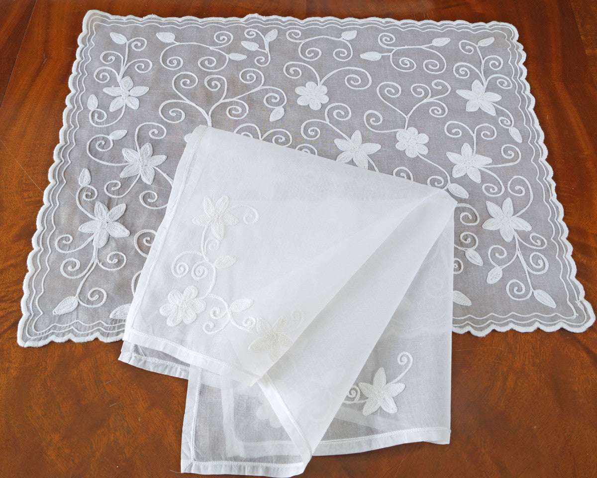 Cotton organdy placemat and napkin set is embroidered with star like motif and finished scalloped edge. 20" napkin has matching embroidery in 2 corners. Shown in white on white.