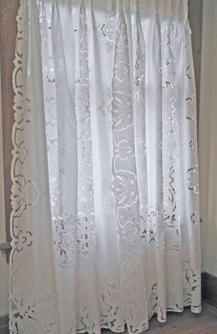 Linen window panels, richly decorated with hand embroidery and finished with pleats at top. All white.