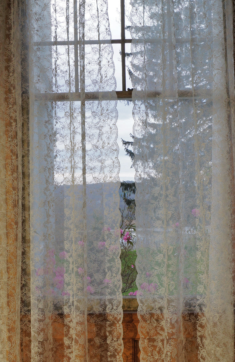 Lace curtain decorated with delicate braid forming tulip like flowers on sheer netting.