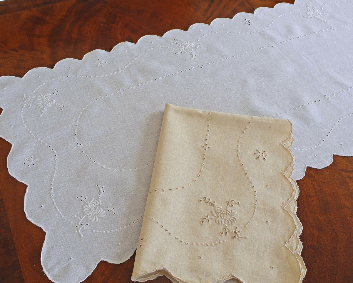 Hand embroidered table runner or dresser scarf. Hand embroidered with scalloped edge and floral motifs.