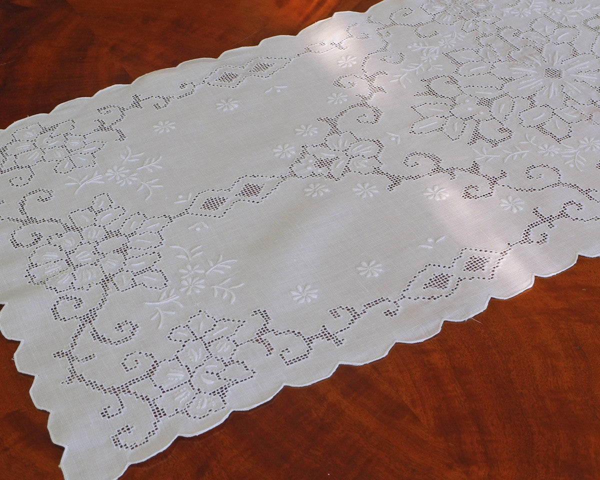 Table runner or dresser scarf hand embroidered on 100% linen using drawn work style needlework. 44"x 16".