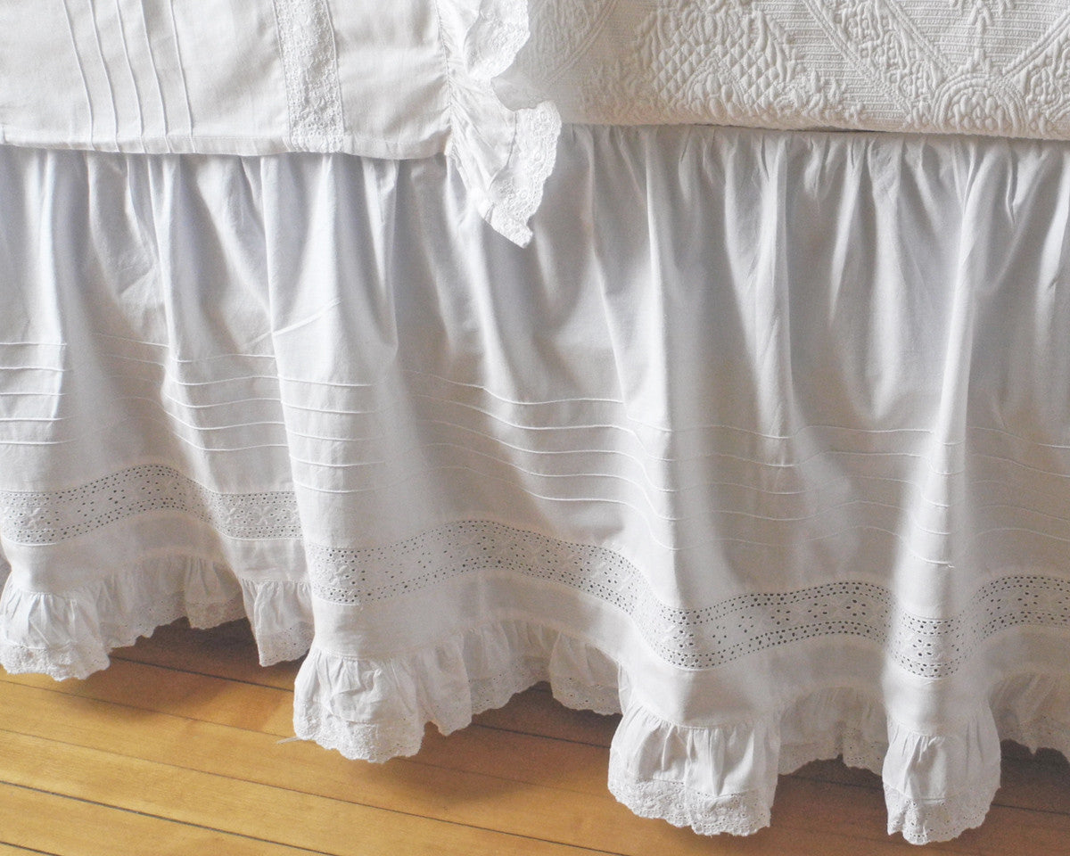 100% cotton dust skirt decorated with several rows of tucks, lace inset and ruffle on the bottom edge.